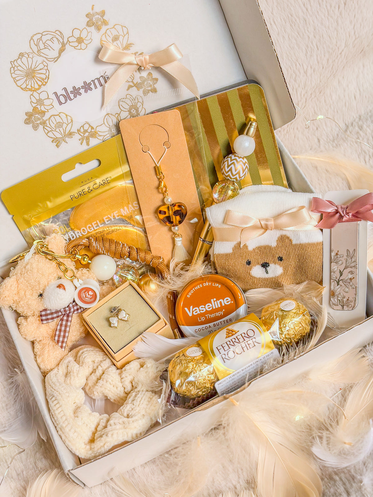 Vue en biais du coffret cadeau ourson BloomLov ouvert avec ses accessoires et chocolats