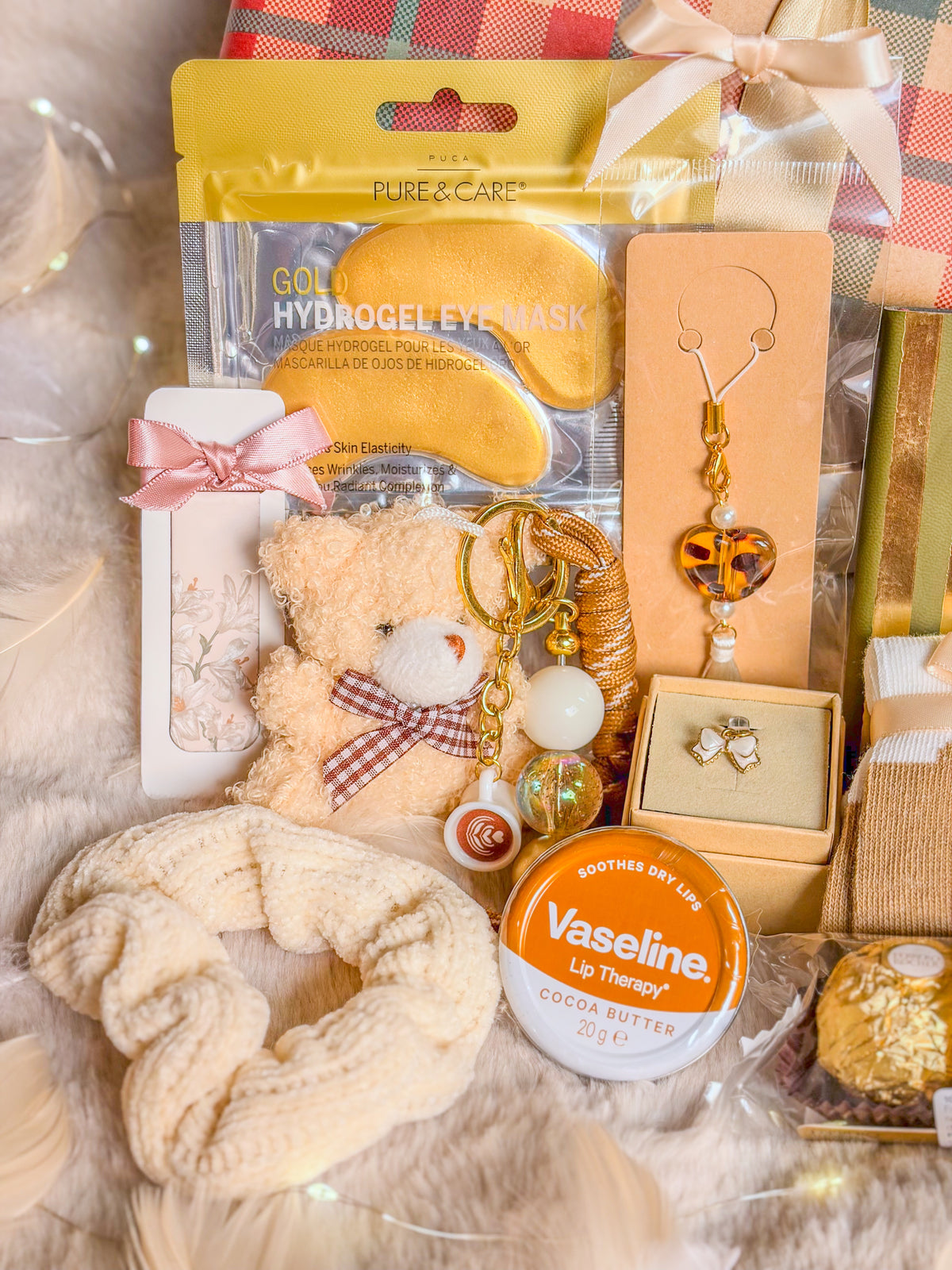 Détail du coffret ourson : patchs pour les yeux, chouchou crème, bag charm et soin lèvres Vaseline