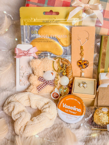 Détail du coffret ourson : patchs pour les yeux, chouchou crème, bag charm et soin lèvres Vaseline