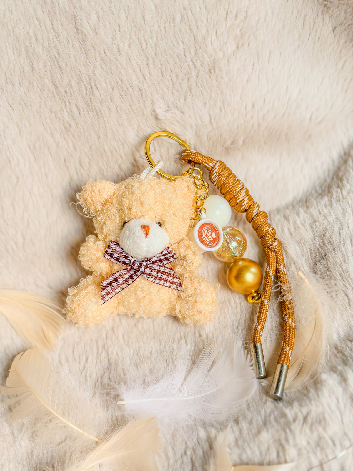 Bag charm BloomLov avec ourson en peluche, nœud à carreaux et cordon doré