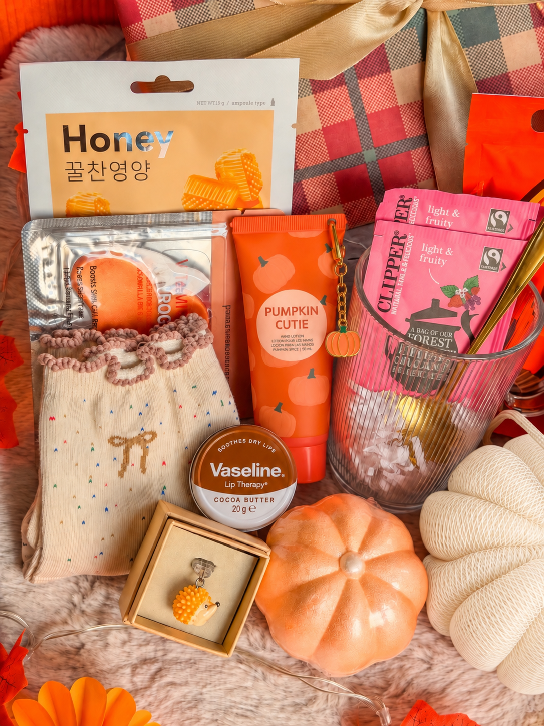 Gros plan sur les soins et les chaussettes : Soins du coffret BloomLov avec masque au miel, patchs yeux, crème pour les mains Pumpkin Spice et baume à lèvres.
