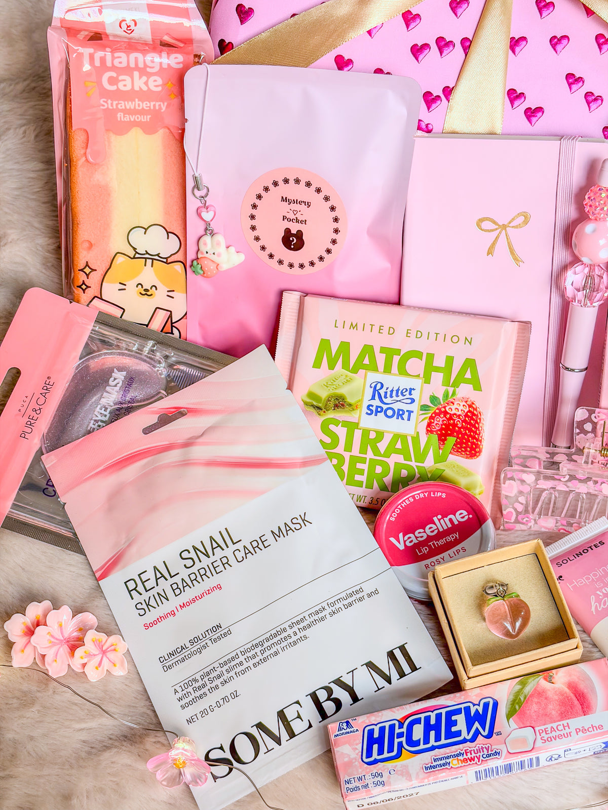 Masques visage et yeux, pochette Mystery Pocket, carnet rose et gourmandises de la box BloomLov