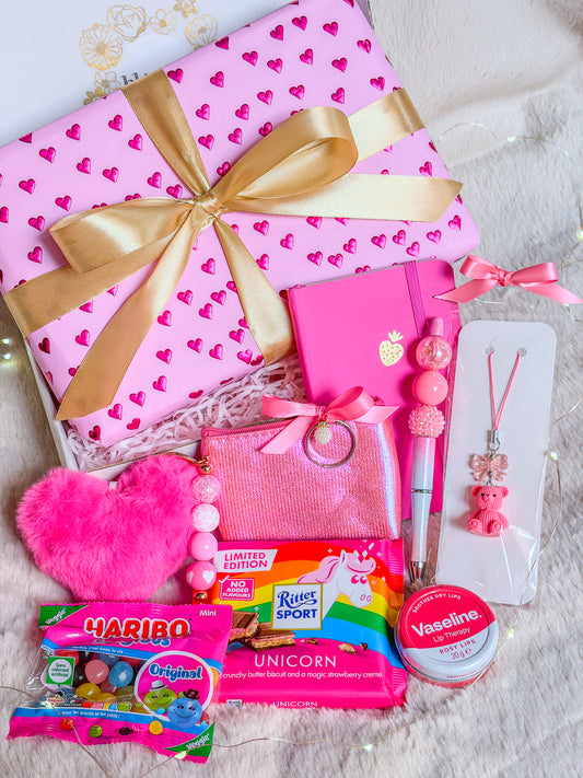 Pink Girly Box avec paquet rose à cœurs, ruban doré, accessoires assortis, chocolat licorne et bonbons


