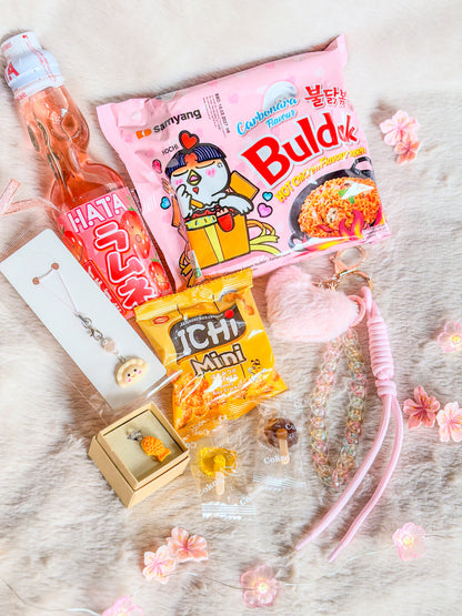 Contenu de la box asiatique BloomLov à plat : Buldak, Ramune, crackers, deux bonbons et trois accessoires kawaii