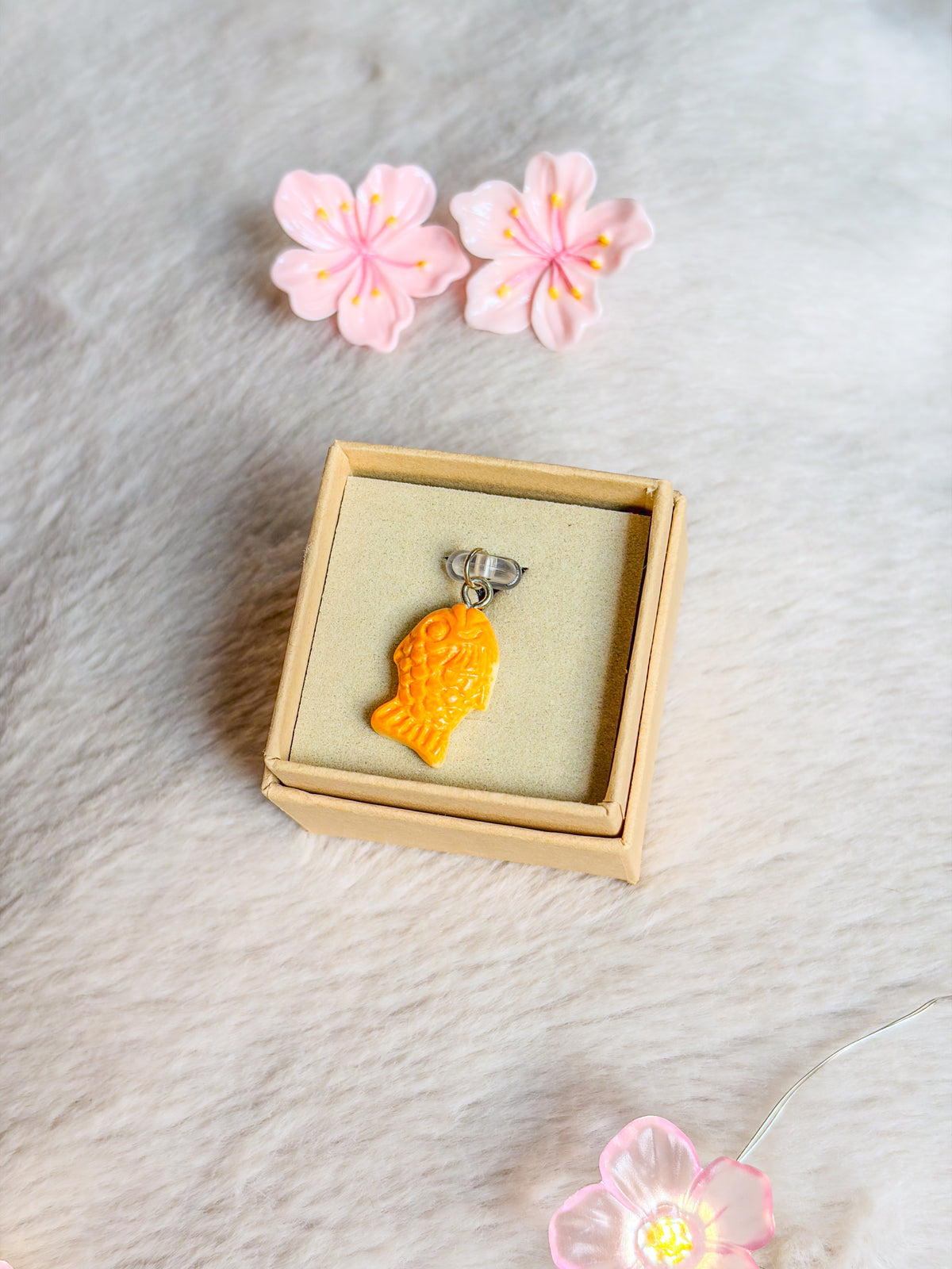 Bouchon anti-poussière taiyaki BloomLov en forme de poisson orange, présenté dans son écrin
